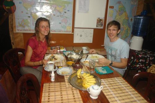 a man and a woman sitting at a table with food at HOMESTAY CAMPING ANURADHAPURA in Anuradhapura