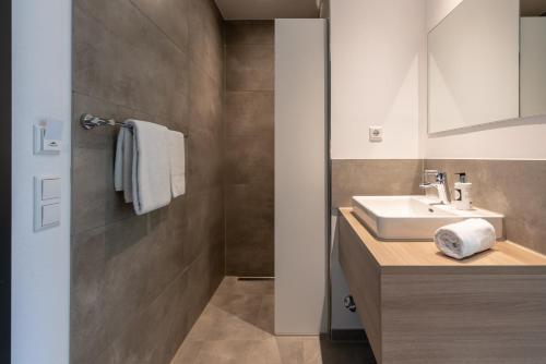 a bathroom with a sink and a mirror at a2 HOTELS Denkendorf - Airport & Messe in Denkendorf