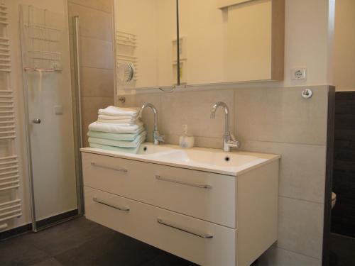 a bathroom with a sink and a mirror and towels at Strandperle 2 in Timmendorfer Strand