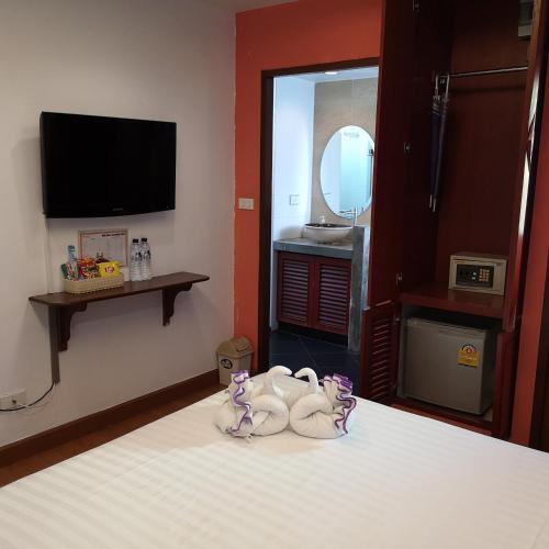 a room with a bed with a tv and two dolls at Korbua House in Bangkok