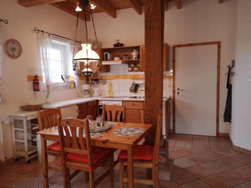 een keuken met een houten tafel met stoelen en een eetkamer bij Gartenwohnung in Norden