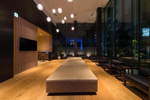 a lobby with a long table in a building at JR Kyushu Hotel Blossom Shinjuku in Tokyo