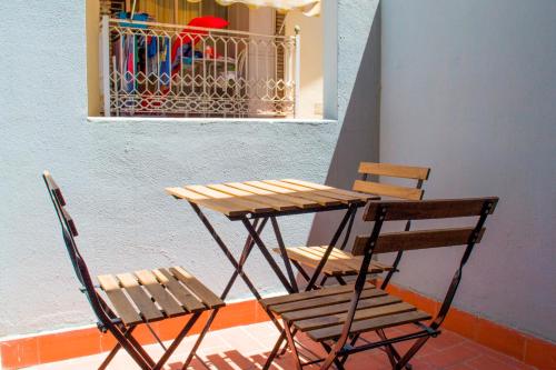 a wooden table and two chairs sitting next to a table and a window at VARADERO DREAMS in Málaga