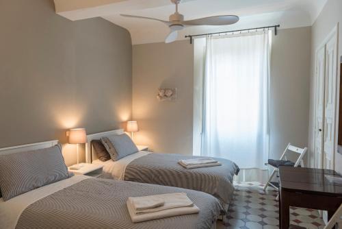 een slaapkamer met 2 bedden en een plafondventilator bij TERRAZZA COCCODE' spazioso con vista mozzafiato! in Lucca