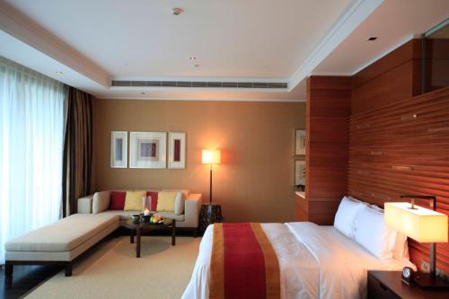 a hotel room with a bed and a couch at Raffles Hainan Clear Water Bay in Sanya
