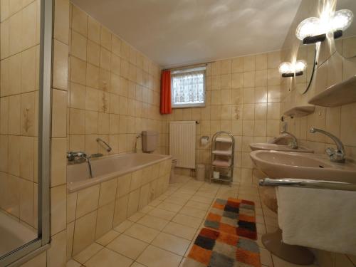 a bathroom with two sinks and a tub and a shower at Ferienwohnungen Grill in Schönberg