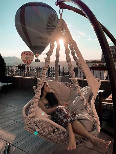 a woman laying in a hammock on a roof at Milat Cave Hotel in Goreme
