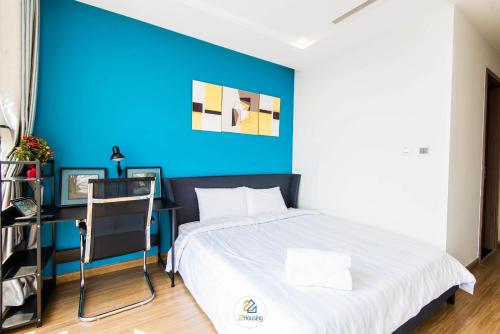 a bedroom with a blue wall and a bed and a desk at Vinhomes Metropolis luxury Hotel & Residence in Hanoi