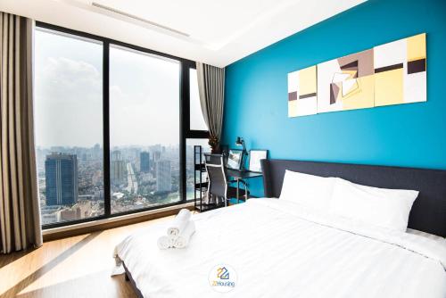 a bedroom with blue walls and a bed and a desk at Vinhomes Metropolis luxury Hotel & Residence in Hanoi