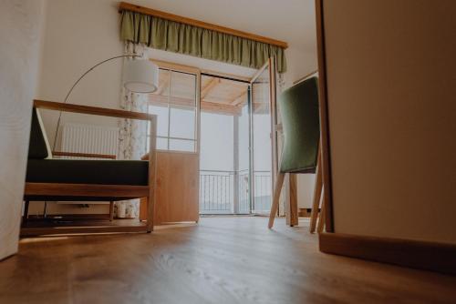ein Wohnzimmer mit einem Spiegel und einem grünen Stuhl in der Unterkunft Winzerhaus am Gamlitzberg in Gamlitz