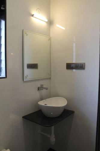 a bathroom with a bowl sink and a mirror at Windchime Cottages in Alibaug