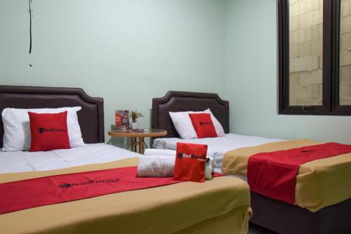 Postel nebo postele na pokoji v ubytování RedDoorz Syariah near DBL Arena 2