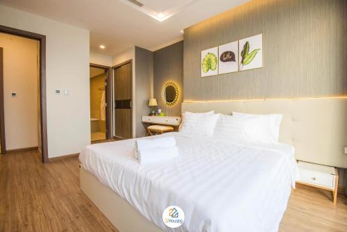 a bedroom with a large white bed and a desk at Vinhomes Metropolis luxury Hotel & Residence in Hanoi