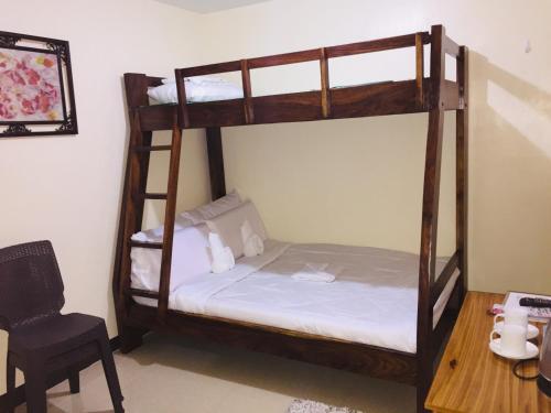 a bedroom with two bunk beds and a desk at JaiJai's Backpackers in Coron