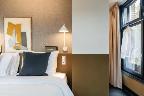 a hotel room with a bed and a window at The Hunfeld in Utrecht