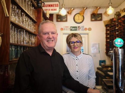 un homme et une femme debout dans un bar dans l'établissement Townsend House Guest House, à Birr