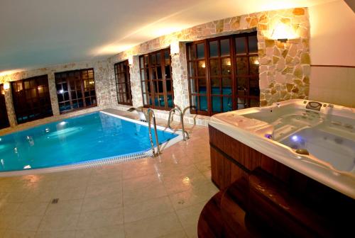 a large bathroom with a tub and a swimming pool at Dwór w Zabużu in Zabuże