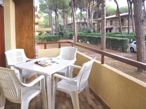 - Balcón con mesa blanca y 4 sillas en Michelangelo Beach, en Lignano Sabbiadoro