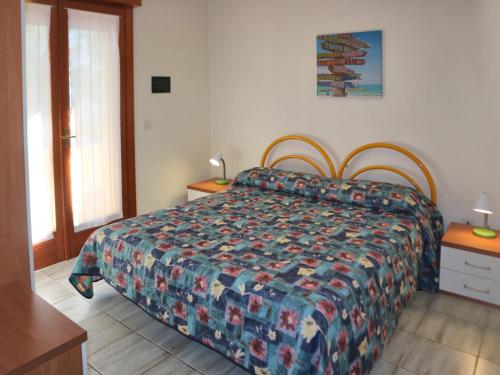 1 dormitorio con 1 cama con colcha colorida en Michelangelo Beach, en Lignano Sabbiadoro