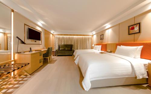 a hotel room with two beds and a television at Royal Dragon Hotel in Macau