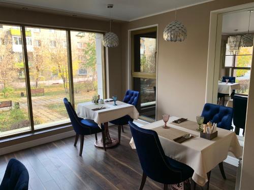 a restaurant with two tables and chairs and a window at Comilfo in Magnitogorsk