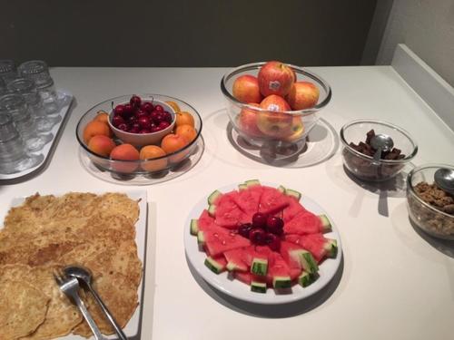 a table with bowls of fruit and a plate of watermelon at Résidence Villemanzy in Lyon