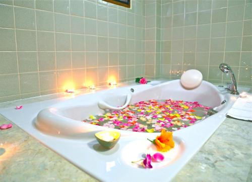 Oriental Siam Resort - SHA Extra Plus Certified في شيانغ ماي: حوض الاستحمام مليء بالكثير من المرشات