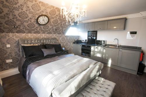 a bedroom with a bed and a clock on the wall at Apartments at Number 10 The Abbey in Norwich