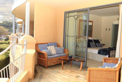 a balcony with a chair and a bed in a bedroom at 29 The Village in Hout Bay