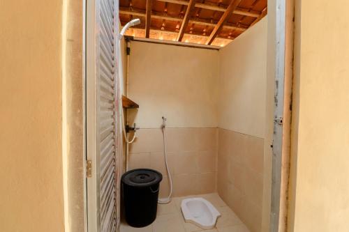 een kleine badkamer met een toilet in een kamer bij Omah Watu Blencong in Sermo