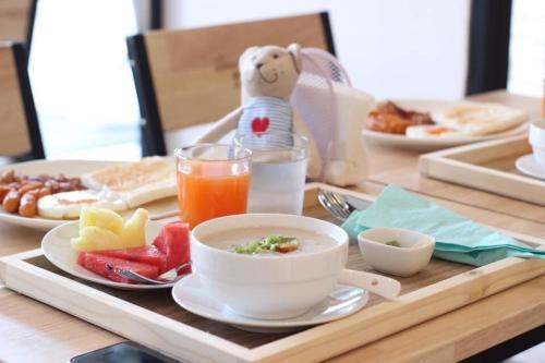 uma bandeja de pequeno-almoço com uma tigela de comida e uma bebida em Bonne Nuit Hotel, Hua Hin em Hua Hin