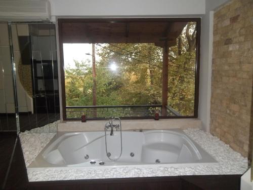 a bath tub in a bathroom with a window at Nostos Hotel in Kato Loutraki