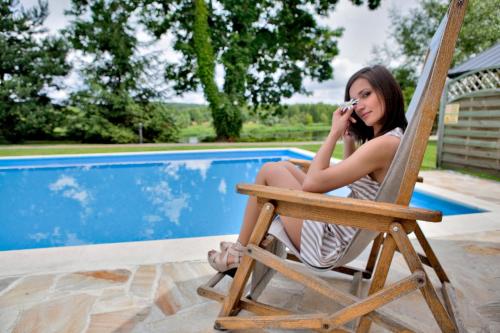 a woman sitting in a chair talking on a cell phone at Dwór w Zabużu in Zabuże
