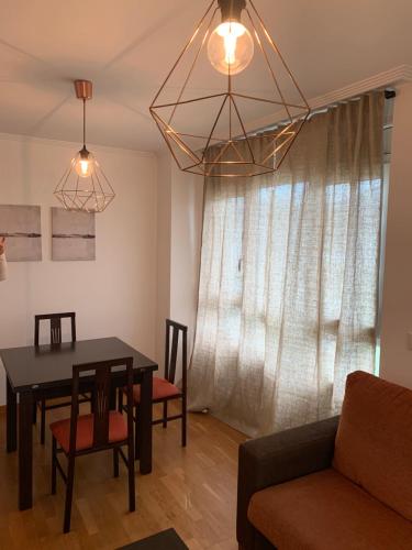 sala de estar con mesa, sillas y sofá en BYHOUSE Castelao, en Sarria