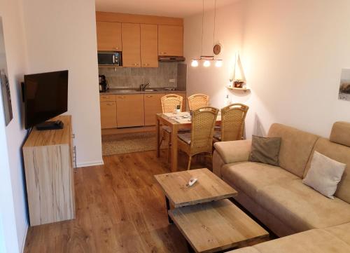 ein Wohnzimmer mit einem Sofa und einem Tisch in der Unterkunft Maritime Ferienwohnung in Strandnähe in Dorum Neufeld