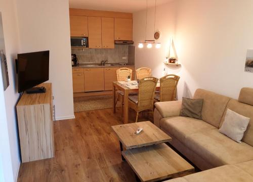 a living room with a couch and a table at Maritime Ferienwohnung in Strandnähe in Dorum-Neufeld