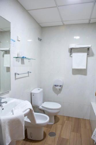 a white bathroom with a toilet and a sink at Hotel Sierra Mar in La Unión