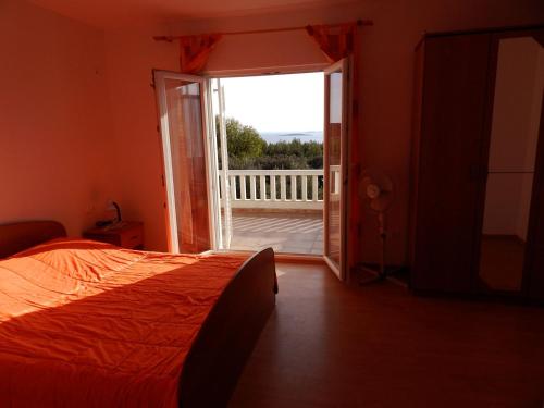 a bedroom with a bed and a door to a balcony at Apartments Senny in Orebić