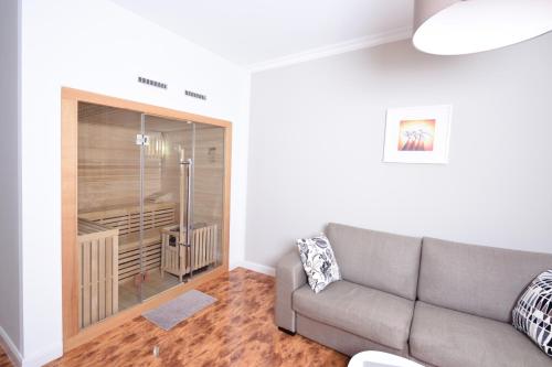 a living room with a couch and a glass wall at Apartments-Leipzig in Leipzig