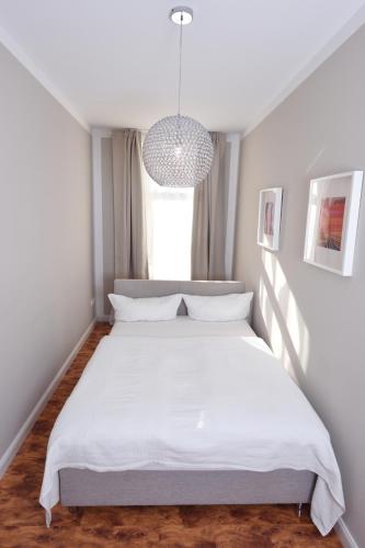 a bedroom with a large white bed in a room at Apartments-Leipzig in Leipzig