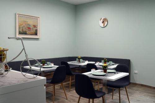 une salle à manger avec des tables et des chaises et une horloge au mur dans l'établissement Napoliseason Rooms & Breakfast, à Naples