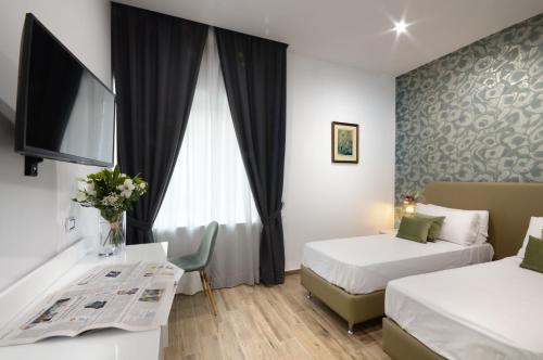 une chambre d'hôtel avec deux lits et une télévision dans l'établissement Napoliseason Rooms & Breakfast, à Naples