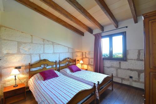 sypialnia z łóżkiem z fioletowymi poduszkami i oknem w obiekcie 081 Finca Els Tarongers ETV5766 by Mallorca Charme w mieście Muro