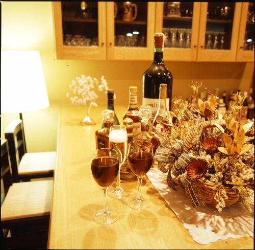 a table with wine glasses and a basket of flowers at Hotel Taigakukan in Hakuba
