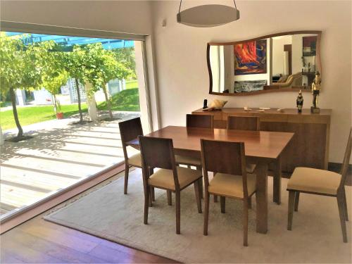 a dining room with a table and chairs and a mirror at Villa Colares in Sintra