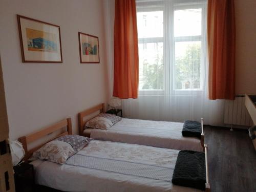 2 camas en una habitación con ventana en Old School Zagreb, en Zagreb