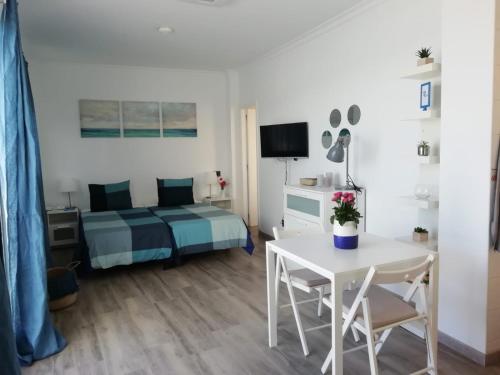 1 dormitorio con 1 cama, mesa blanca y sillas en Vista Canteras, en Las Palmas de Gran Canaria