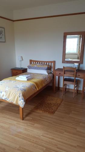 a bedroom with a bed, desk, chair and a lamp at Kilcreeny Lodge in Lisburn