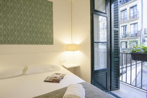 ein Schlafzimmer mit einem Bett und einem großen Fenster in der Unterkunft MAI BY OLDTOWN APARTMENTS in San Sebastián