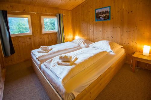 a bedroom with a large bed in a wooden room at Feriendorf Tauerngast in Hohentauern